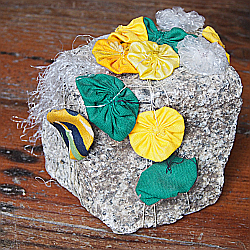 ein mit Blumen aus Plastik geschmückter Pflasterstein