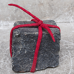 kleiner Pflasterstein mittels Filzkordel zum Geschenk eingebunden