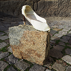 Ein aus Kreppband geformter und geklebter Stöckelschuh mit einem Farbstift als Absatz